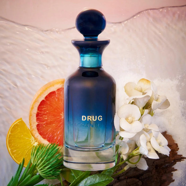Blue perfume bottle labeled 'Drug' with fruit and flowers on a textured surface