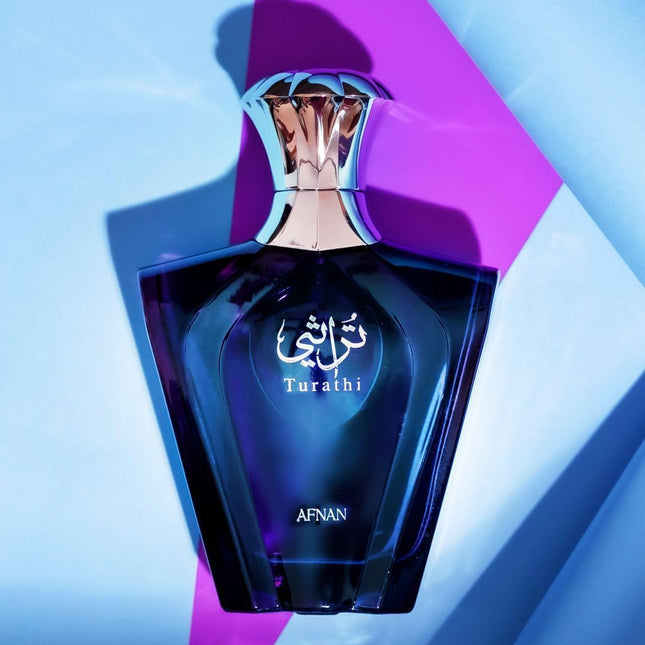 Blue perfume bottle with 'Turathi' and 'Afnan' branding on a geometric background