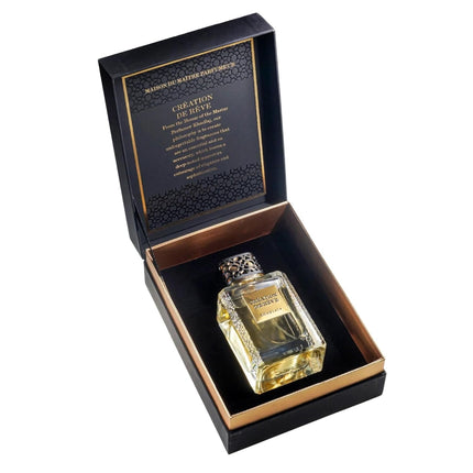 Perfume bottle in a black box with gold accents on a white background