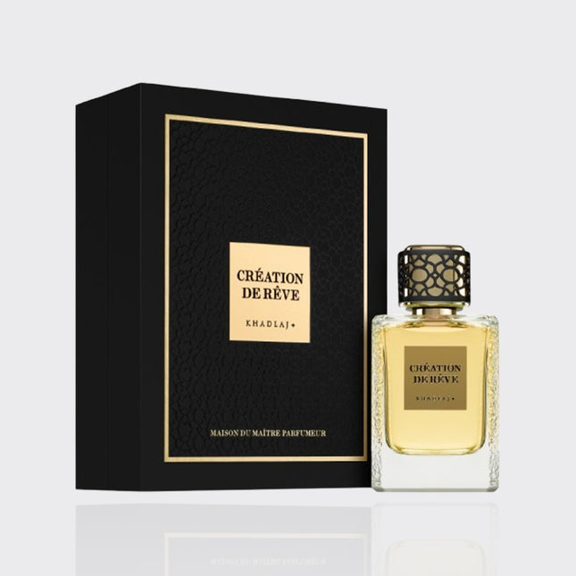 Perfume bottle and packaging with 'Creation de Reve' branding on a light gray background