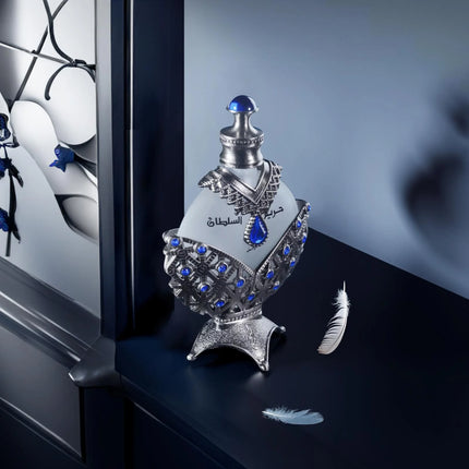 Decorative bottle with blue accents on a dark surface with feathers