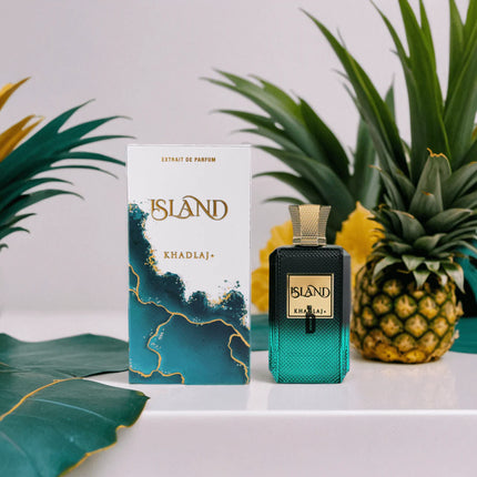 Perfume bottle and packaging with 'Island' branding against a white background with green leaves and a pineapple.