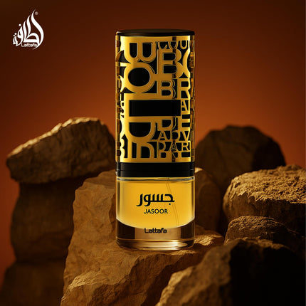 Perfume bottle labeled 'Jasoor' by Lattefa on a rocky background