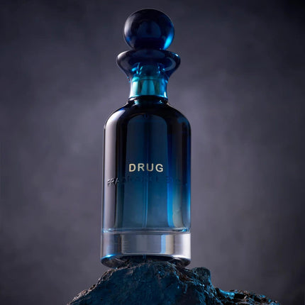 Blue glass bottle labeled 'Drug' on a dark background