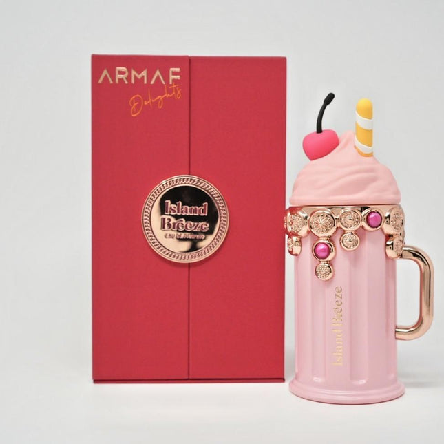 Pink milkshake-shaped perfume bottle with decorative elements in front of an Armaf box.