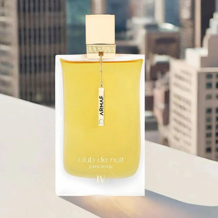 Yellow perfume bottle with 'ARMAE' branding on a blurred cityscape background