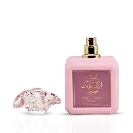 Pink perfume bottle with decorative cap on a white background