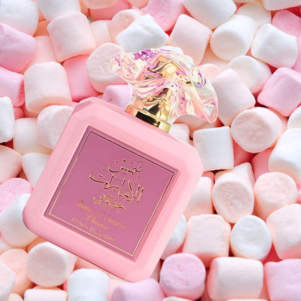 Pink perfume bottle with gold accents on a bed of pink and white marshmallows